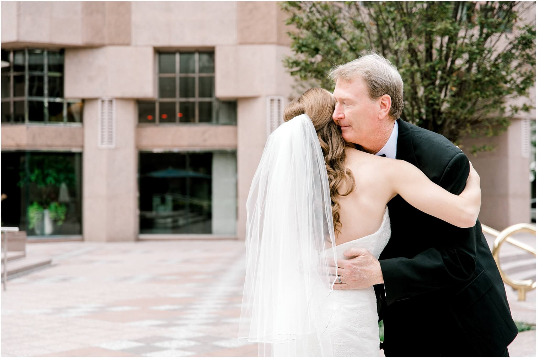 father hugging daughter at charlotte wedding