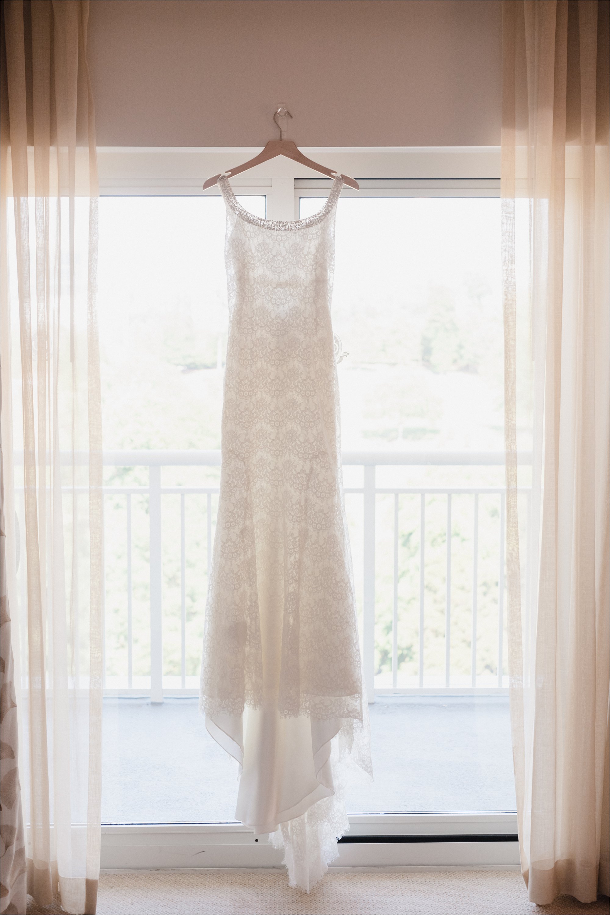 Lace wedding dress hanging in window
