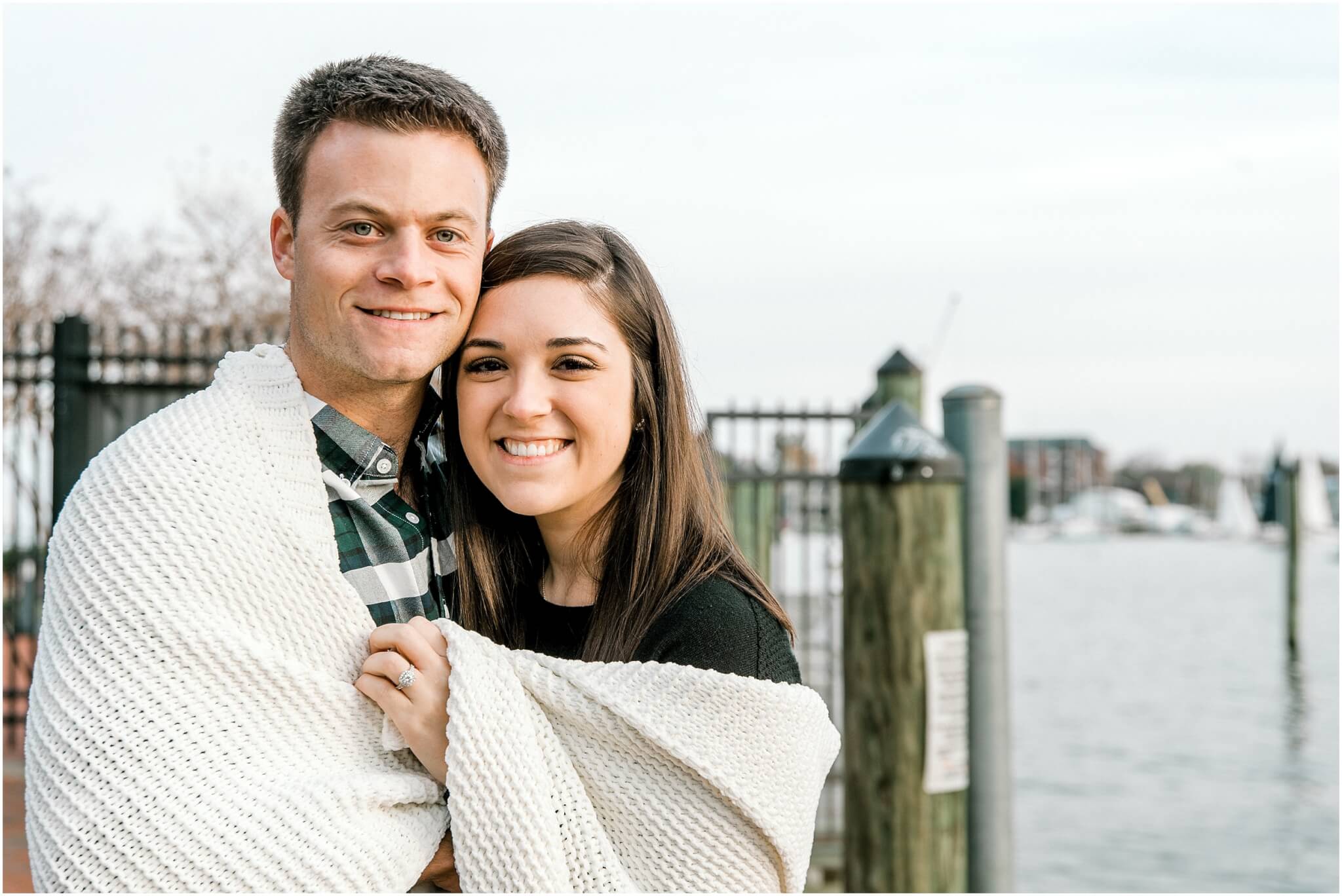 couple wrapped up in a blanket during their annapolis engagement session 