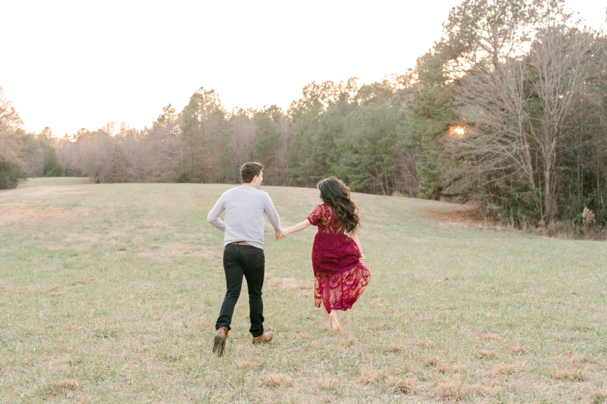 couple running into the sunset at engagement session