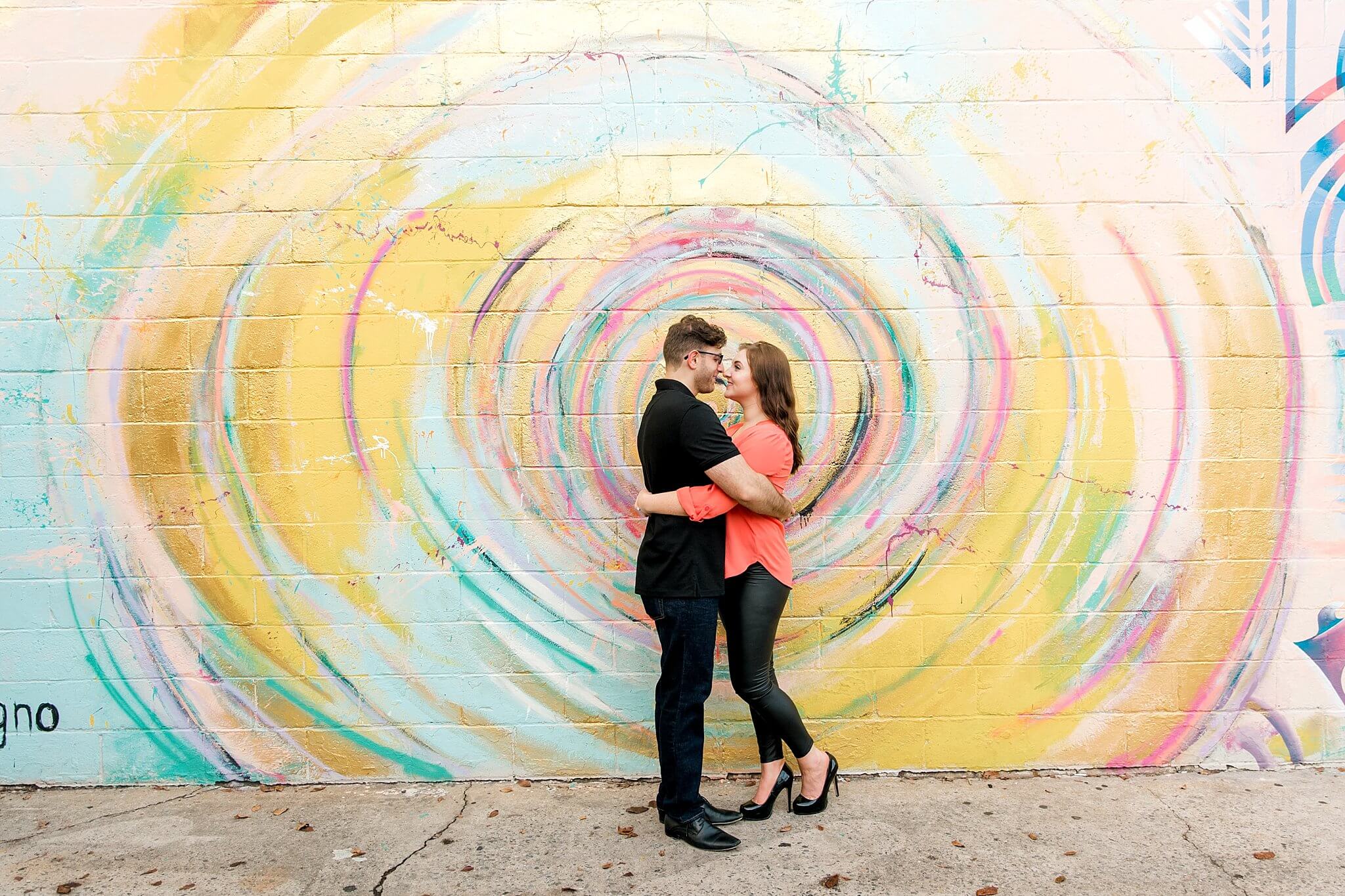 couple standing in front of charlotte mural for engagement pictures