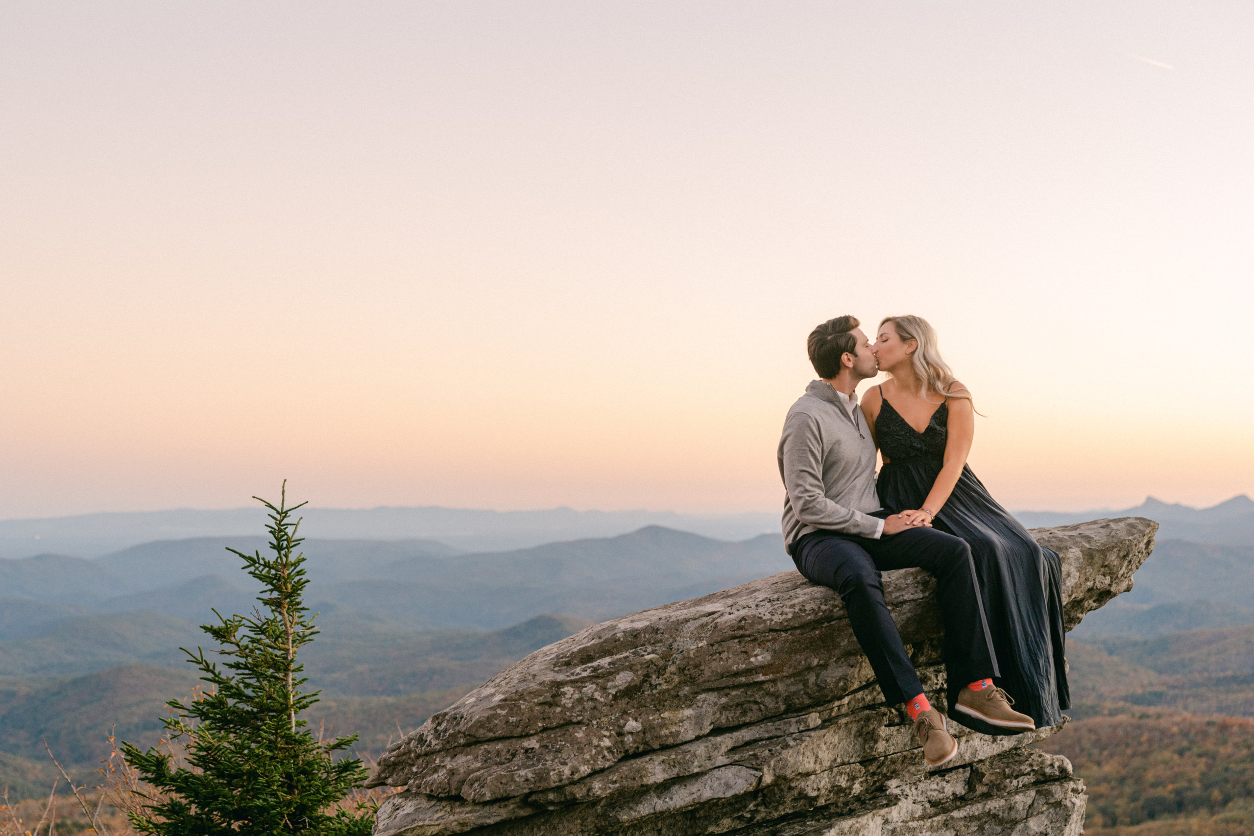 Couple kissing at sunset on top of mountain