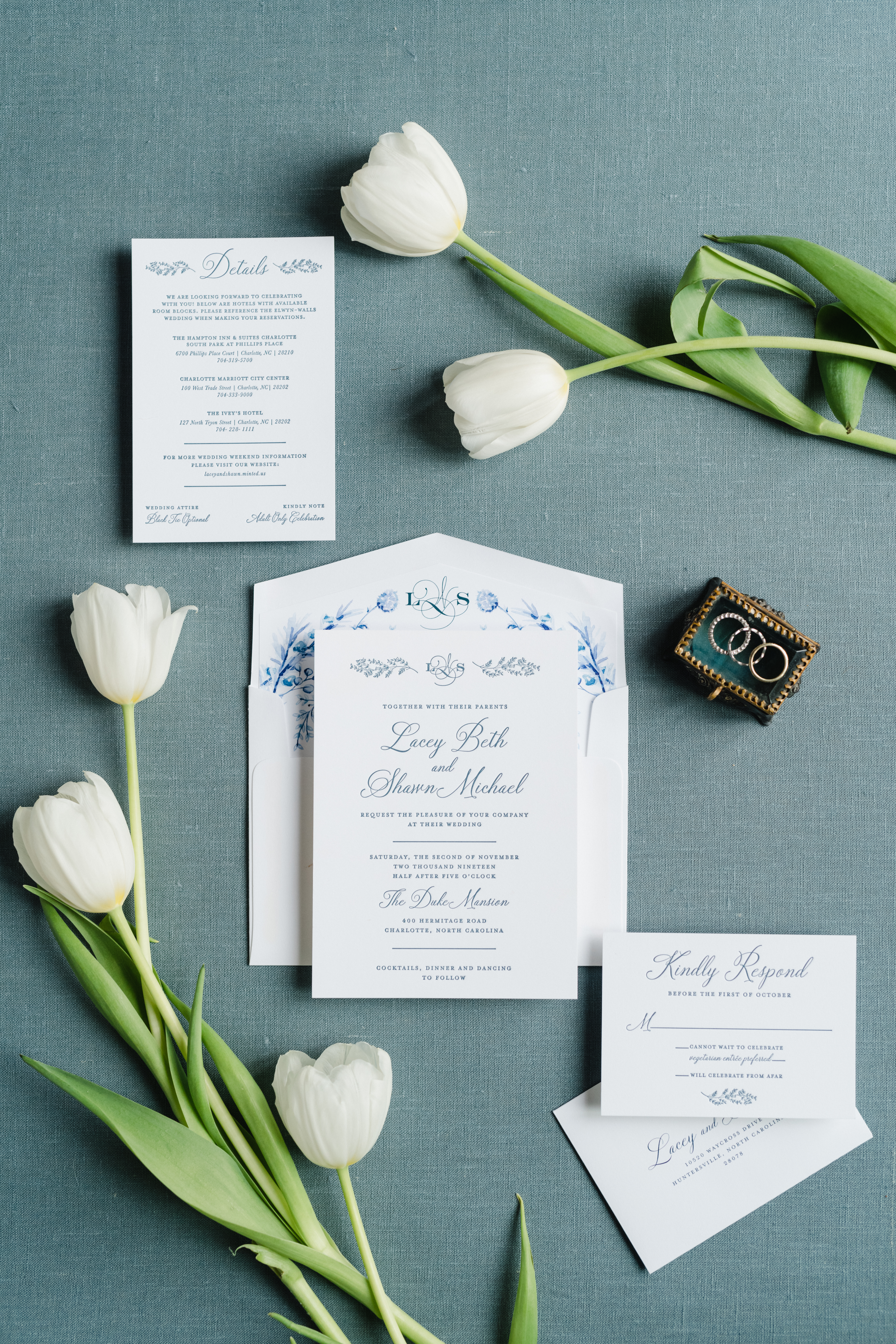 White wedding invitation flat lay with blue background