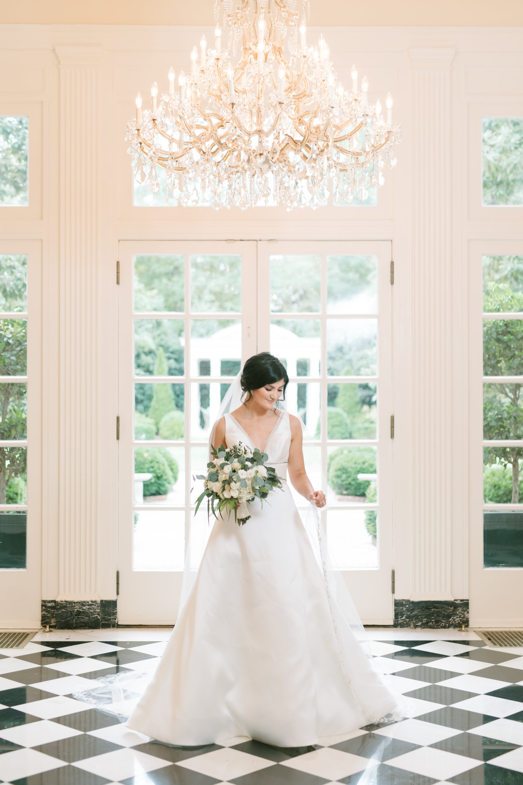 Bride under chandelier inside of The Duke Mansion wedding venue in Charlotte, North Carolina