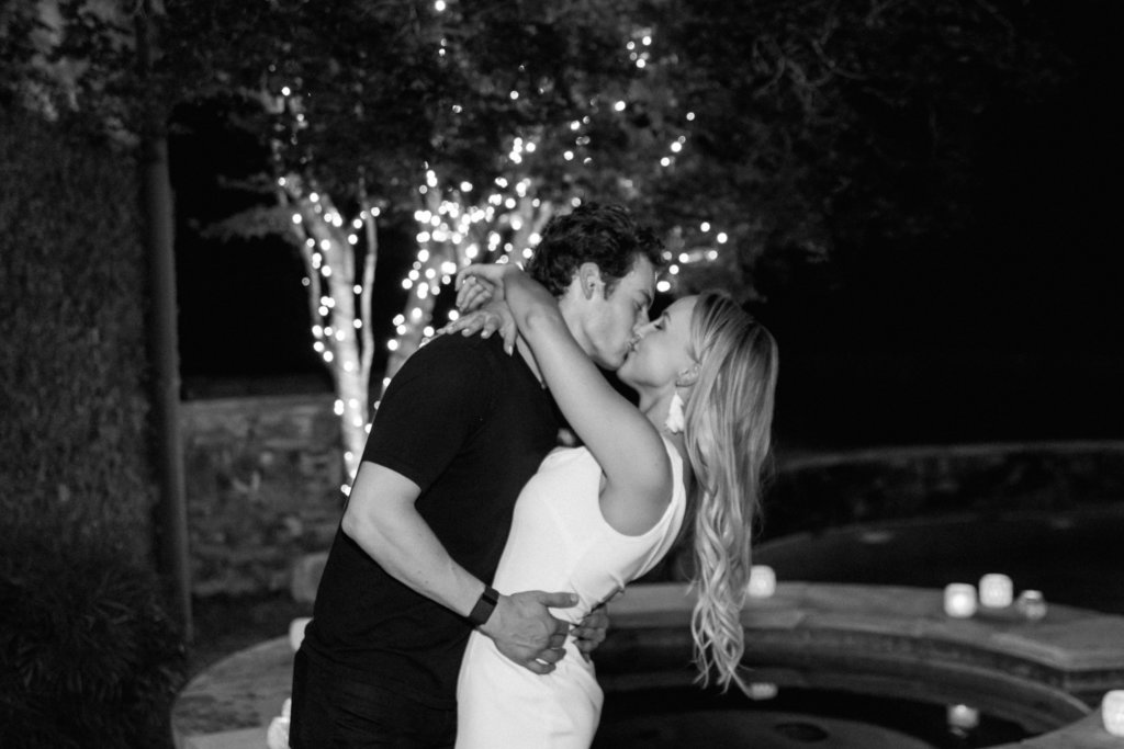 Black and white photo of couple kissing at engagement party